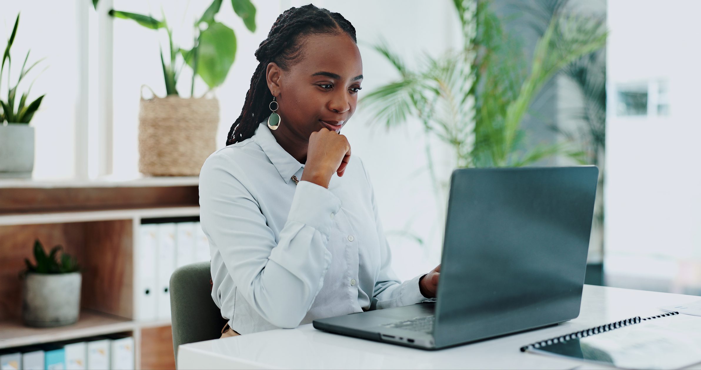 Business woman, thinking and laptop for online research in office and information on digital tech at desk. Black person, editor and inspiration on internet and creative writing on computer on blog Woman working on laptop in office.